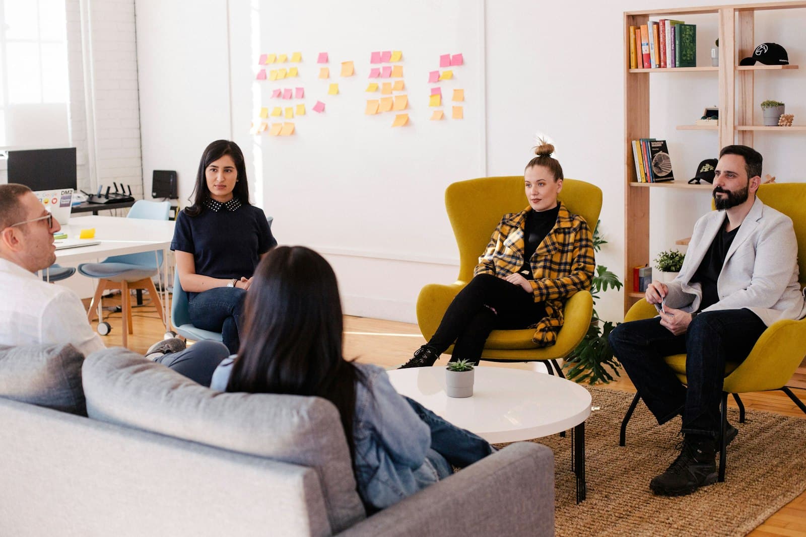 Colleagues chatting in comfortable armchairs in a bright lounge